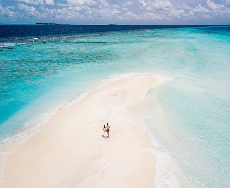 277746_GettyImages_1176156364_Young-adult-couple-standing-on-a-sandbank-against-turquoise-water-in-Maldives (3).jpg